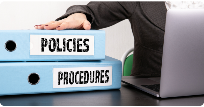 Policies and procedures folders Policies and procedures folders placed beside a desktop computer.